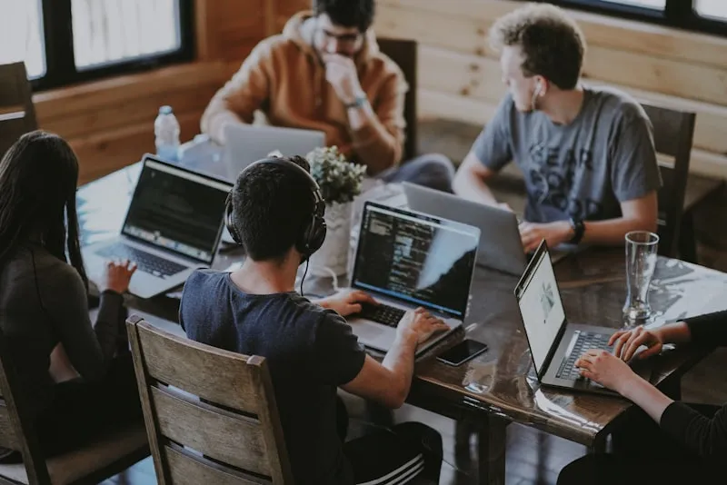 People gathered around a laptop, sharing and discussing